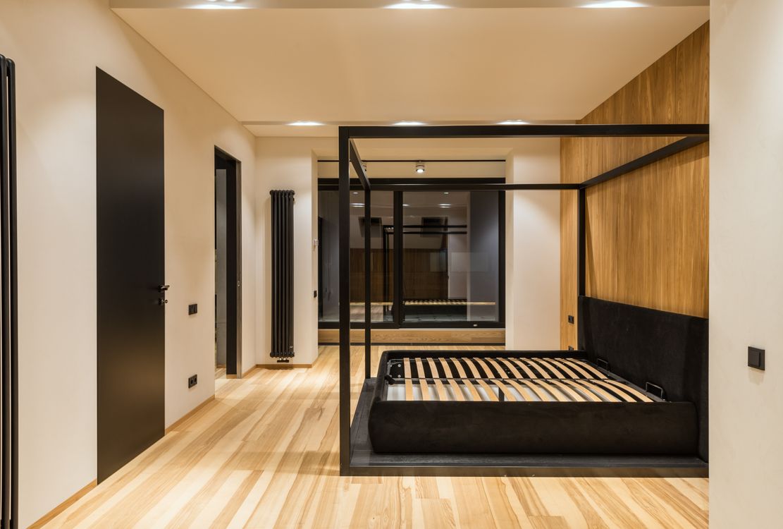 Modern bedroom with parquet floor and large window ideal for radiant floor heating