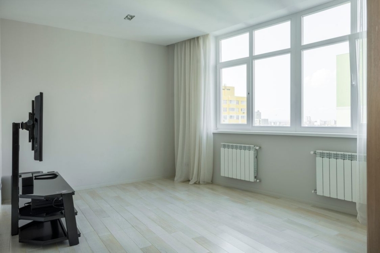 Spacious modern home interior with bright hardwood floors and large windows ideal for whole house radiant heating