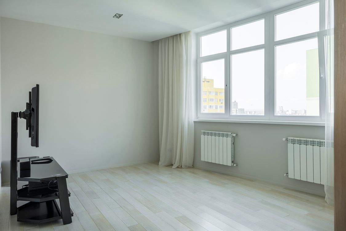 Spacious modern home interior with bright hardwood floors and large windows ideal for whole house radiant heating